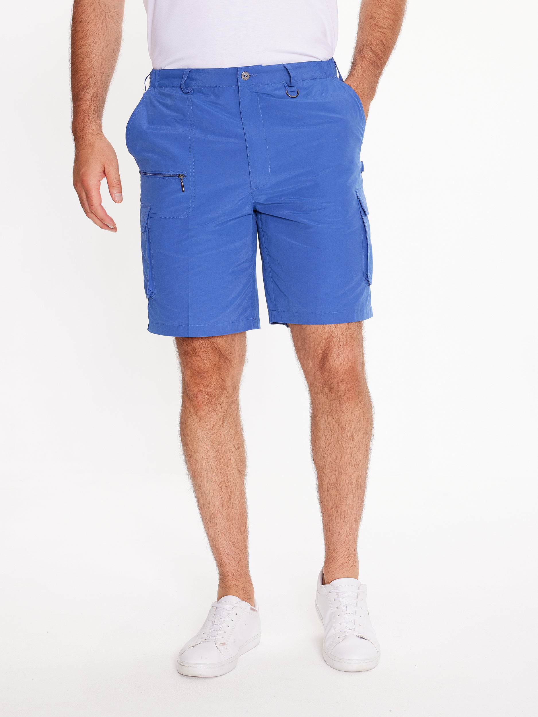 Front image of model wearing the mens Woodbury Short in blue. Short is knee length, has button fly, belt loops, side cargo and slanted pockets, and a front zip pocket.Model has hand in side pocket.